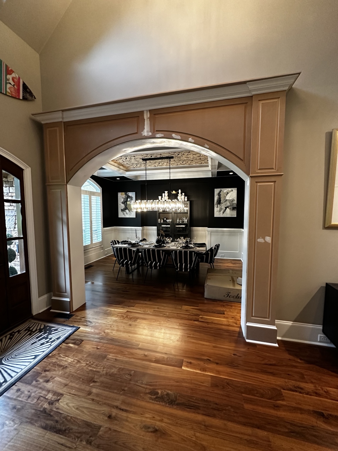Arched dining-room opening during construction with unpainted trim and visible filled joints