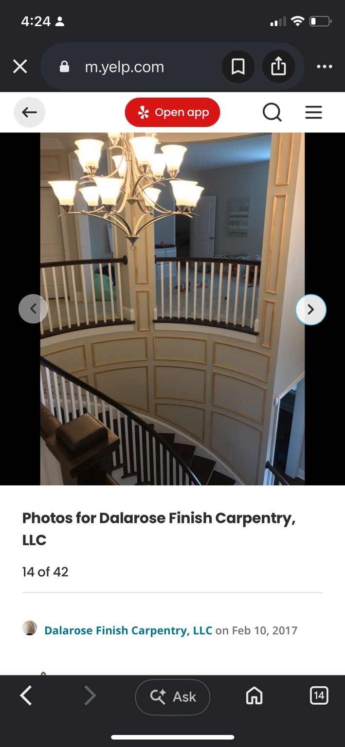 Curved stairwell with picture-frame wood molding around the landing and down the stair wall before painting
