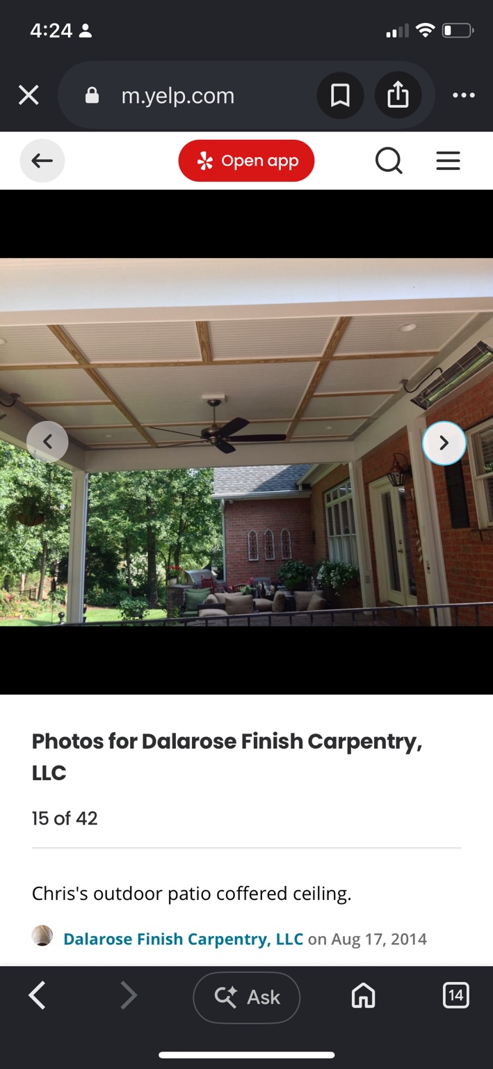 Covered outdoor patio with a grid of wood trim over a white beadboard ceiling and a ceiling fan