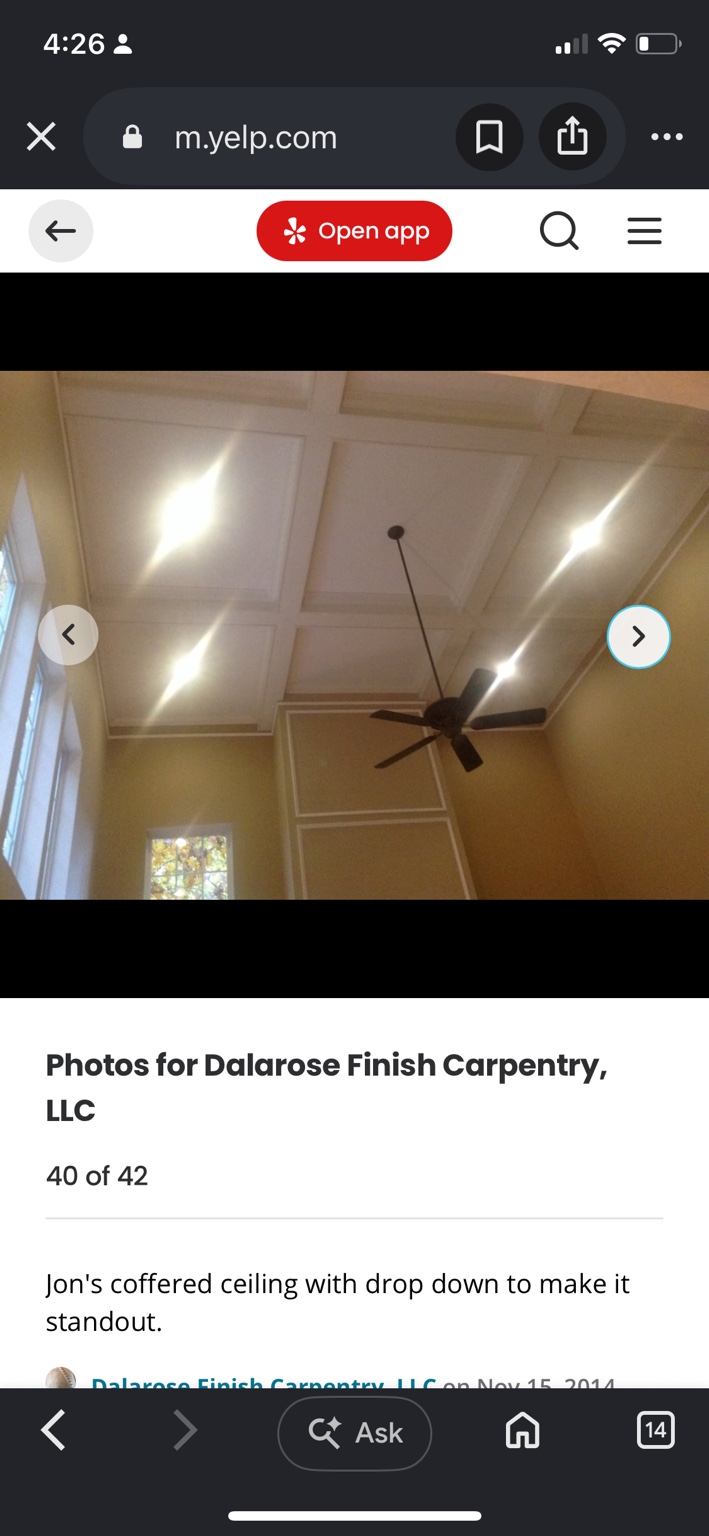 White coffered ceiling with a dropped border above a living room and ceiling fan