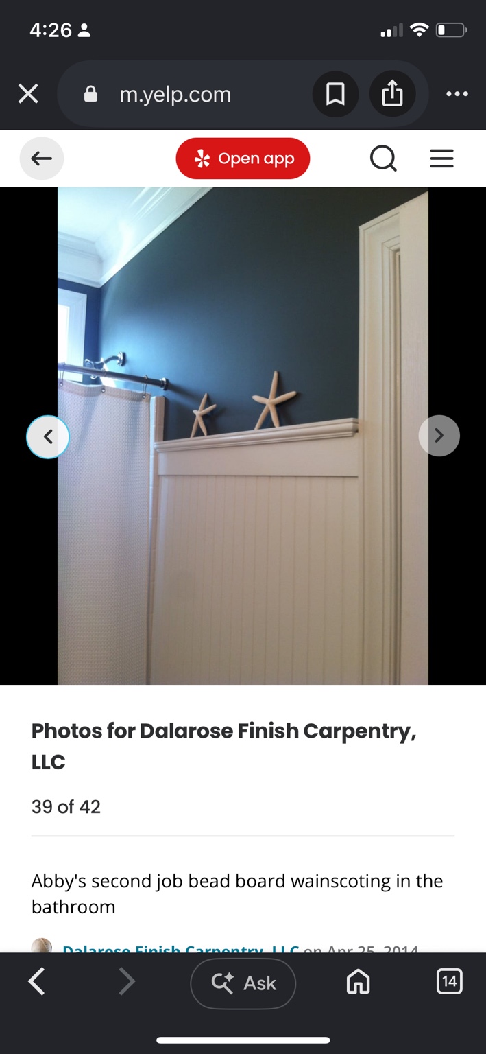 White beadboard wainscoting and a wide cap rail below a blue bathroom wall