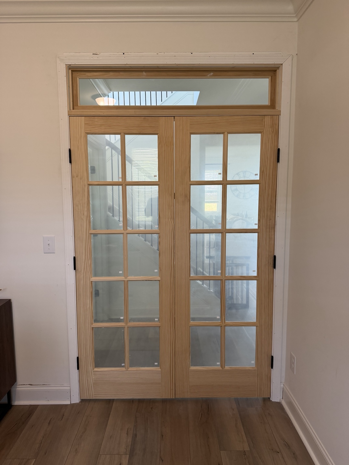 New glass double-door installation seen from inside the office, before final finish and hardware