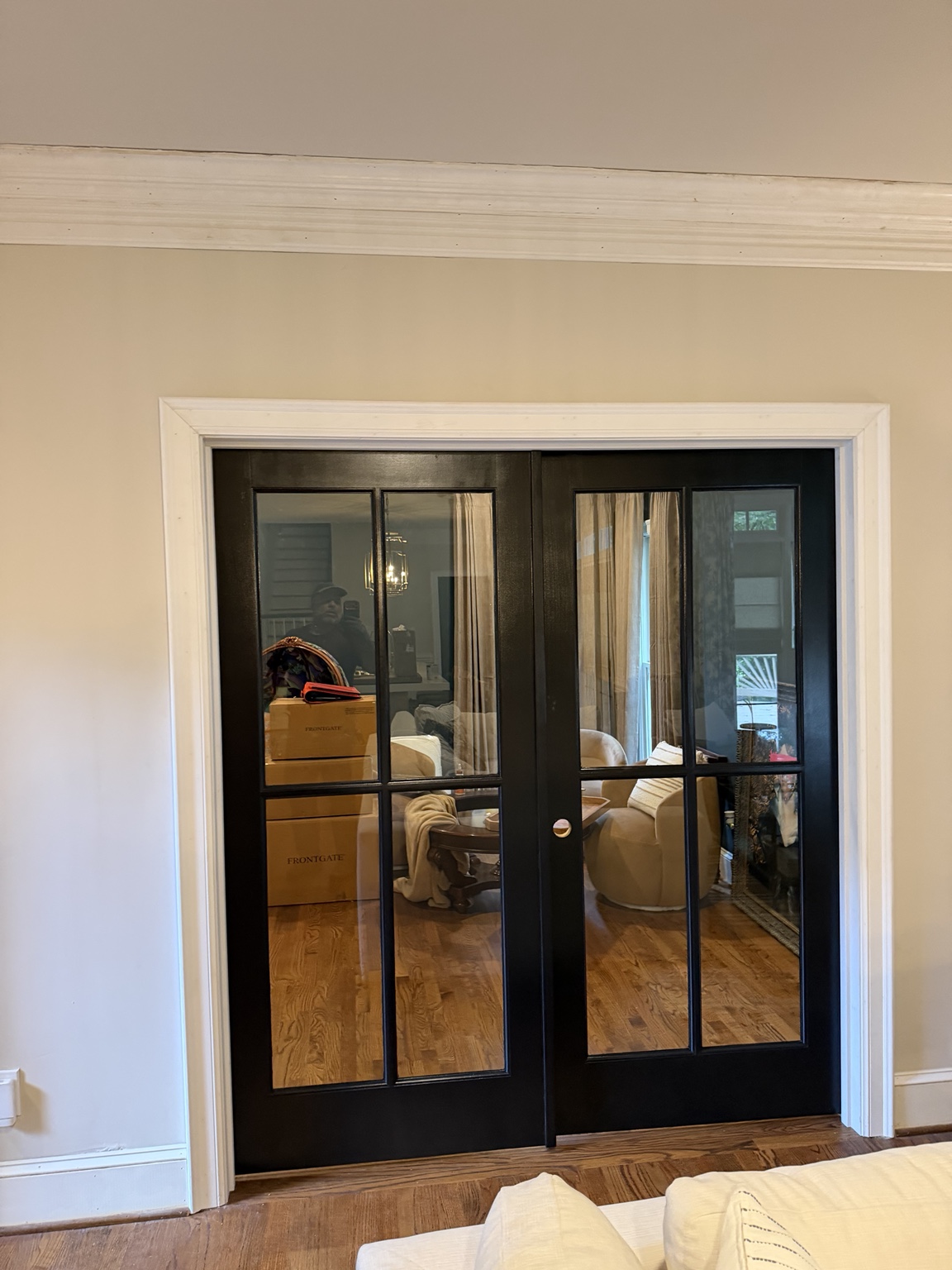 Black glass-panel double doors with white trim in a light-colored room
